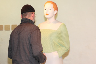 Ein Besucher betrachtet eine Installation in Form eines Menschen