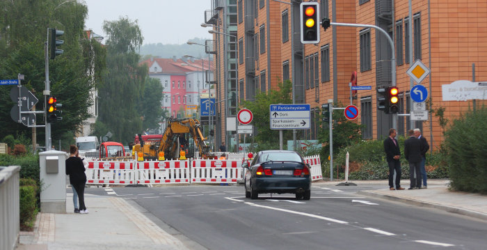 Foto: Verkehr rollt wieder durch die Walkmühlstraße © Stadtverwaltung Erfurt Ein PKW passiert biegt auf einer neu gebauten Kreuzung mit Lichtsignalanlage nach link ab, im Hintergrund ist die Straße noch eine Großbaustelle.