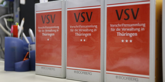 Drei dicke Bücher stehen mit dem rot-grauen Rücken zum Betrachter. Darauf steht "Vorschriftensammlung für die Verwaltung in Thüringen".
