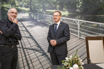 Vor der Leinwand mit einem Bild der Brücke am Espachbad stehen Bürgeramtsleiter Peter Neuhäuser und Architekt Albrecht von Kirchbach.