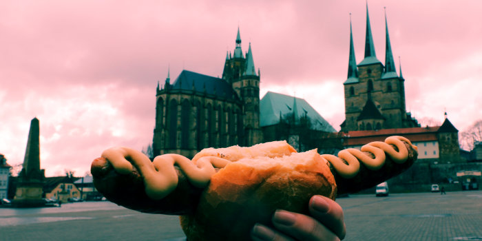 Bratwurst auf Domplatz Eine Bratwurst wird vor dem Dom in die Höhe gehalten.