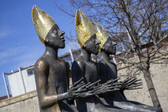 drei Skulpturen mit goldenen Mützen
