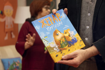 In den Händen eines Mannes ist ein Buch in ukrainischer Sprache.