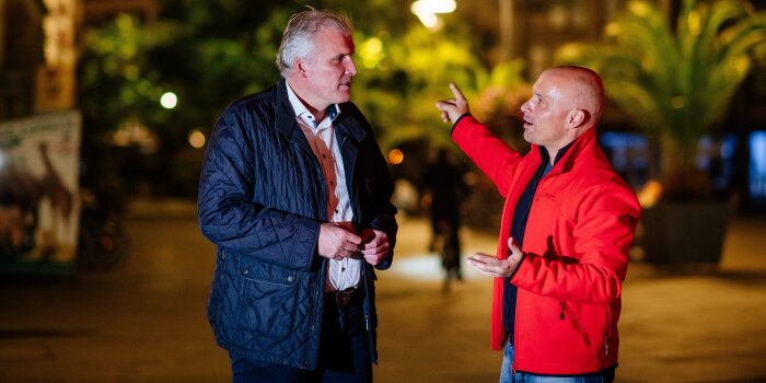 Zwei Männer diskutieren miteinander in der Öffentlichkeit.