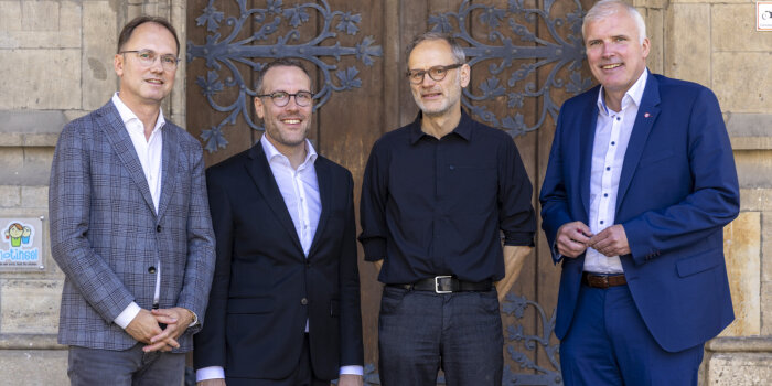 vier Männer stehen vor der Tür des Erfurter Rathauses