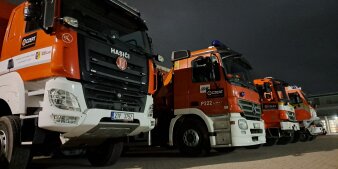 Vier Fahrzeuge eines tschechischen Katastrophenschutz-Teams stehen auf einem Parkplatz. 