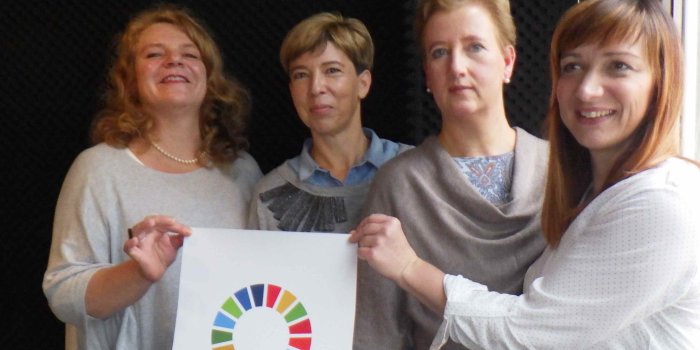 vier Frauen mit Plakat "The Global Goals"