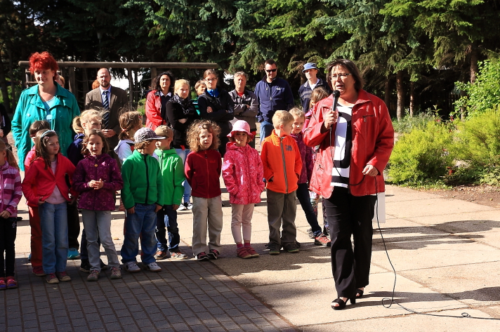 Bürgermeisterin mit Mikrofon vor Schülern einer Grundschule bei der Eröffnung des Schülerfreiwilligentages.