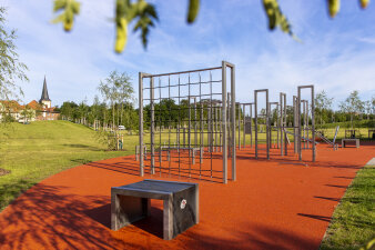 eine Fläche mit verschiedenen Fitnessgeräten in einem Park