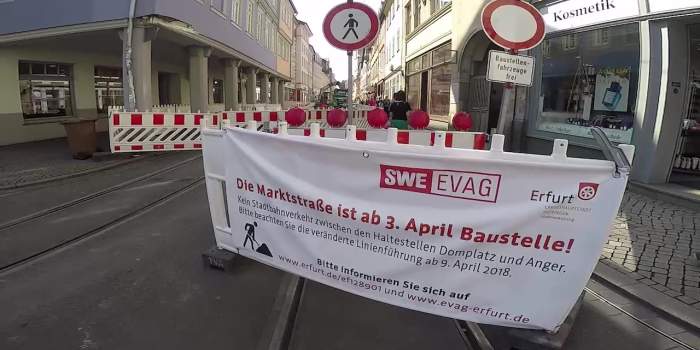 Ein Bauzaun mit Plakat sowie Hinweisschilder auf die Bauarbeiten
