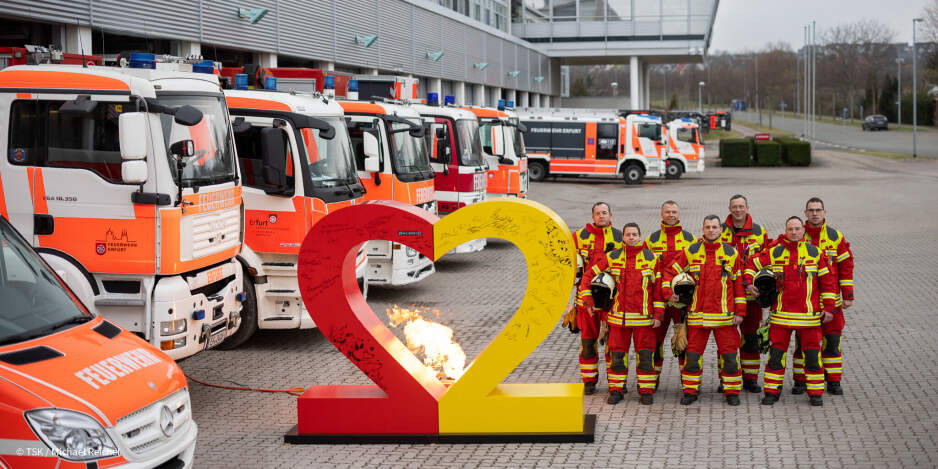 Das Logo zum Tag der Deutschen Einheit - eine herzförmige 22 - mit Kameraden der Feuerwehr und Löschfahrzeugen. 
