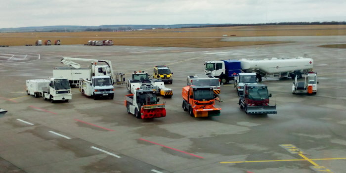 Auf dem Rollfeld des Flughafens stehen verschiedene elektrobetriebene Fahrzeuge. 