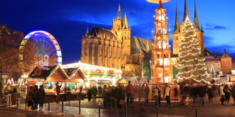 Weihnachtsmarkt mit Riesenrad, Pyramide und Weihnachtsbaum vor beleuchtetem Ensemble von Dom und Severi