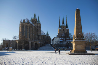 Zu sehen ist der Dom, Severikirche, Obelisk und Domplatz, überzogen mit einer leichten Schneedecke; oberhalb ein strahlend blauer Himmel.