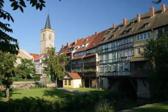 Krämerbrücke Mit Wohnhäusern bebaute Brücke aus sieben Bögen über einem Fluss.