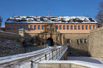 Blick auf die zugeschneite Zitadelle auf dem Petersberg von der Brücke aus, der Weg ist zum Teil geräumt. 