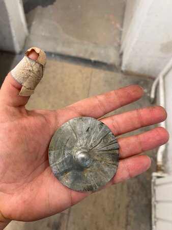 Eine Hand mit einem runden Objekt aus Metall