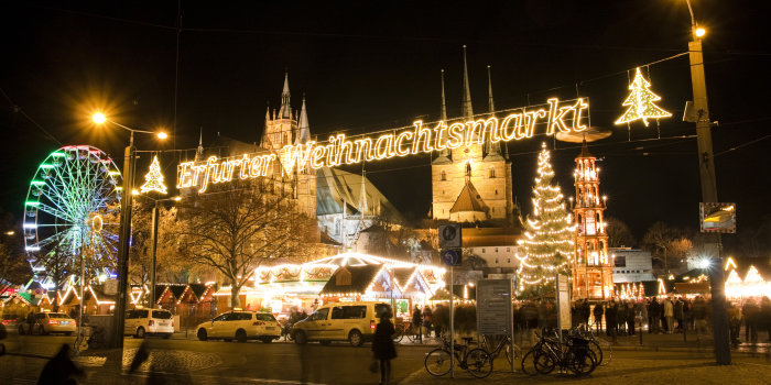 Blick auf den Erfurter Weihnachtsmarkt am Eröffnungsband, links das beleuchtete Riesenrad, im Hintergrund der Dom, im Mittelpunkt das aus Lichterband mit dem Text "Erfurter Weihnachtsmarkt"