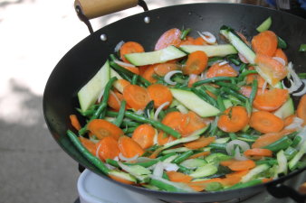 Mohrrüben, Zucchini und Frühlingszwiebeln in einer Stahlpfanne