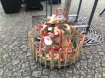 weihnachtlich geschmückter Jutesacj innerhalb eines kleinen Holzzaunes