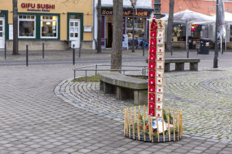 ein rundes, in einen niedrigen Holzzaun eingefasstes, weihnachtliches Arrangement