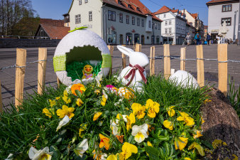 ein kleines eingezäuntes Blumenbeet mit Osterdekoration