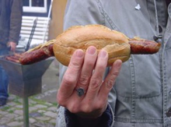 Bratwurst in Brötchen in Hand