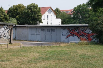 Garagenkomplex mit dem aufgemalten Text "Kunst im Stress"