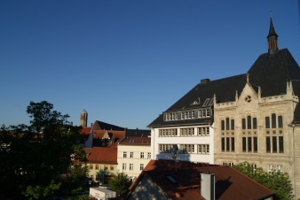 Großes Gebäude rechts, links Blick auf Baumgruppe