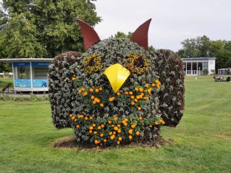 blumenbepflanzte etwa 2 Meter hohe Eule auf Wiese