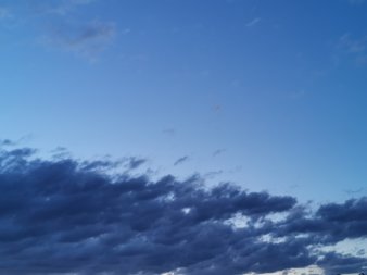 in der unteren Bildhälfte lösen sich dunkelblaue Wolken nach rechts oben hin auf