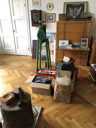 Ein Raum mit gepackten Kisten in der Mitte, im Hintergrund ein Schrank