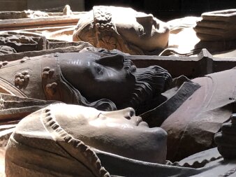 liegende, steinerne Heiligenfiguren