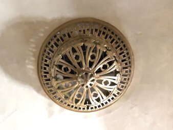 Ein goldenes rundes Ornament mit Löchern an einer Decke hängend