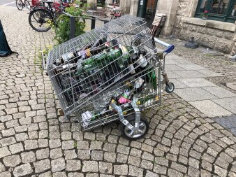 Zwei ineinandergebaute Einkaufswagen mit Pfandflaschen gefüllt