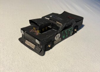 Schwarzes Automodell aus Papier auf einem weißen Untergrund