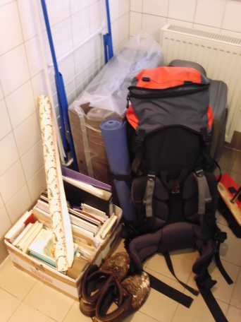 Ein Rucksack und eine Kiste Bücher in einem mit Fliesen verkleideten Raum.