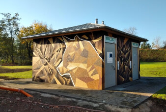 Graffiti-Projekt mit Spraydosen wurde ein Fuchs in Gelb- und Brauntönen an die Fassade einer WC-Anlage gesprüht