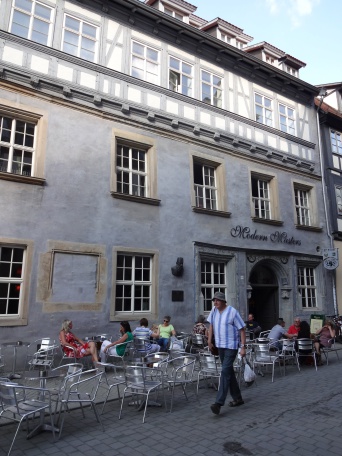 Ein Passant läuft an einem Straßencafé vorbei.