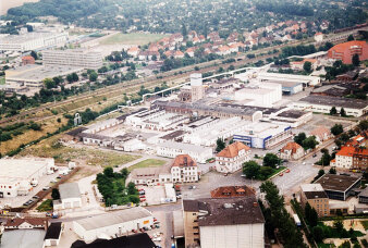 Ein Luftbild eines Industriekomplexes an einer Bahntrasse. 