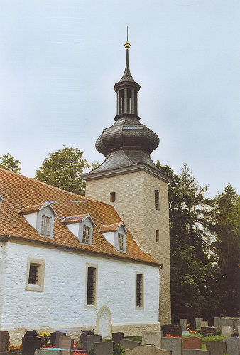 Kirche mit Kirchturm und rotem Dach.