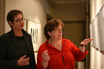 Zwei Kuratorinnen betrachten die Zeichnungen in der Galerie