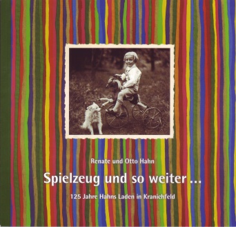 Bild: Ausstellungskatalog "Spielzeug und so weiter ..." © Hahndruck Kranichfeld Historisches Schwarz-Weiß-Foto auf bunt gestreiftem Untergrund. Weiße Schrift unter dem Bild.