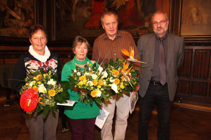 Zwei Damen und ein Herr mit Blumenstrauß, daneben der Gartenamtsleiter, im Rathausfestsaal