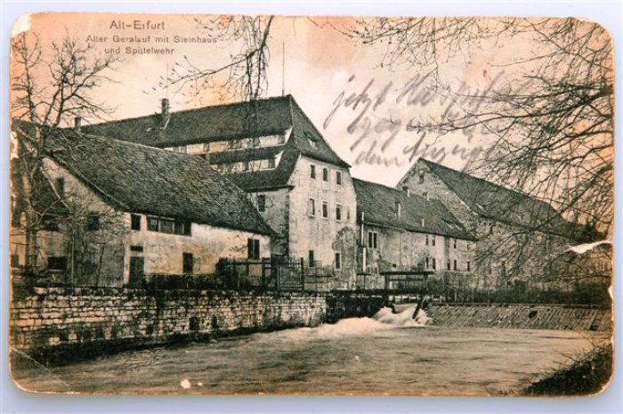 Jenseits des vormaligen Wehrgrabens lebt man im Großen Hospital in einem eigenen Kosmos: Spittelwehr, Herrenhaus und Steinhaus. Ansichtskarte "Alt-Erfurt", um 1890 Häuserzeile, davor ein Fluss mit Wehranlage.