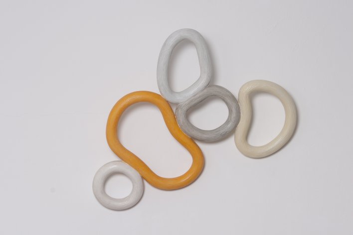 Fünf verbundene Ringe, einer in der Farbe Orange.
