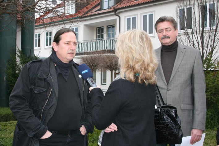 Zwei Herren (links und rechts) und eine Dame vom Mitteldeutschen Rundfunk in der Mitte, die dem linken Herren ein Mikrofon entgegenhält. Im Hintergrund eine Dachterrasse.