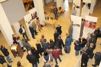 Ein Blick von oben in einen Ausstellungsbereich. Zahlreiche Besucher stehen zwischen den Ausstellungstafeln.