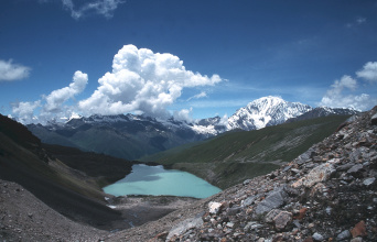 Nepal, der Binnenstaat in Südasien, wird Thema des Symposiums zur Biodiversität des Himalaya sein, welches in Erfurt stattfindet. Eine karge, steinige Landschaft mit hohen, schneebedeckten Bergen. Klarer Himmel und weiße Wolken. In der Mitte, vertieft gelegen, ein See.