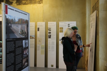 Zwei junge Frauen schauen sich eine der Ausstellungstafeln an.